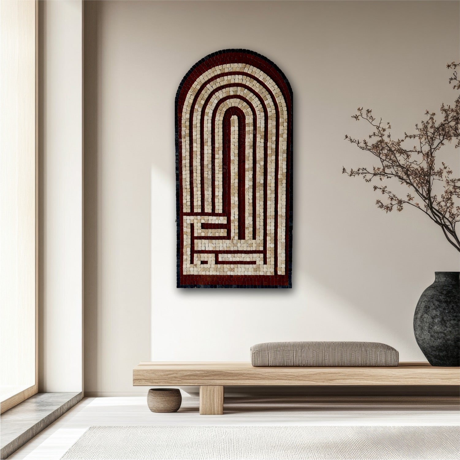 A framed mosaic wall art Al-Humdulilah with black and red stones forming a geometric pattern, displayed on a wall above a shelf with a vase and books.