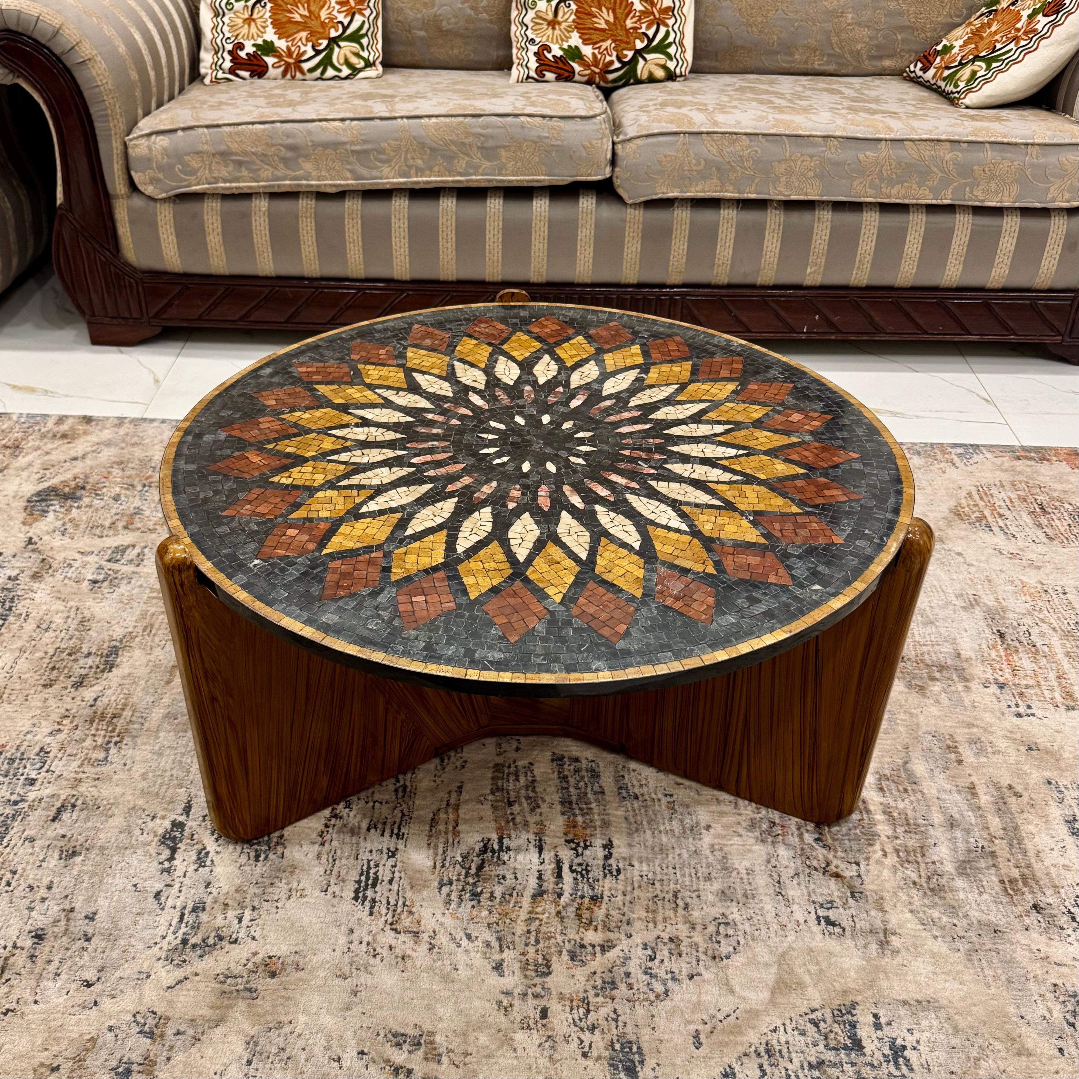 Round coffee table with a decorative top in a living room setting