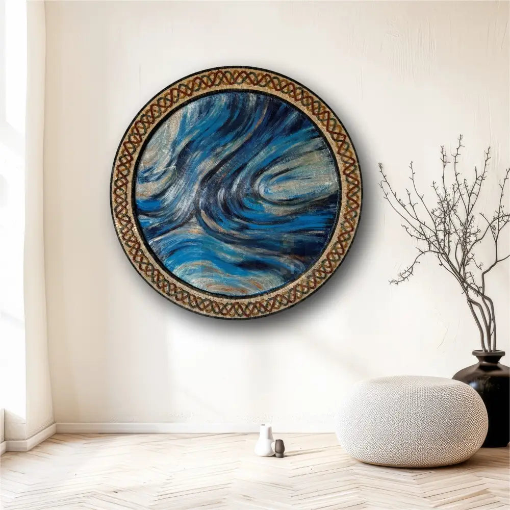 A circular mosaic artwork with blue tones and a geometric patterned frame, displayed on a wall.