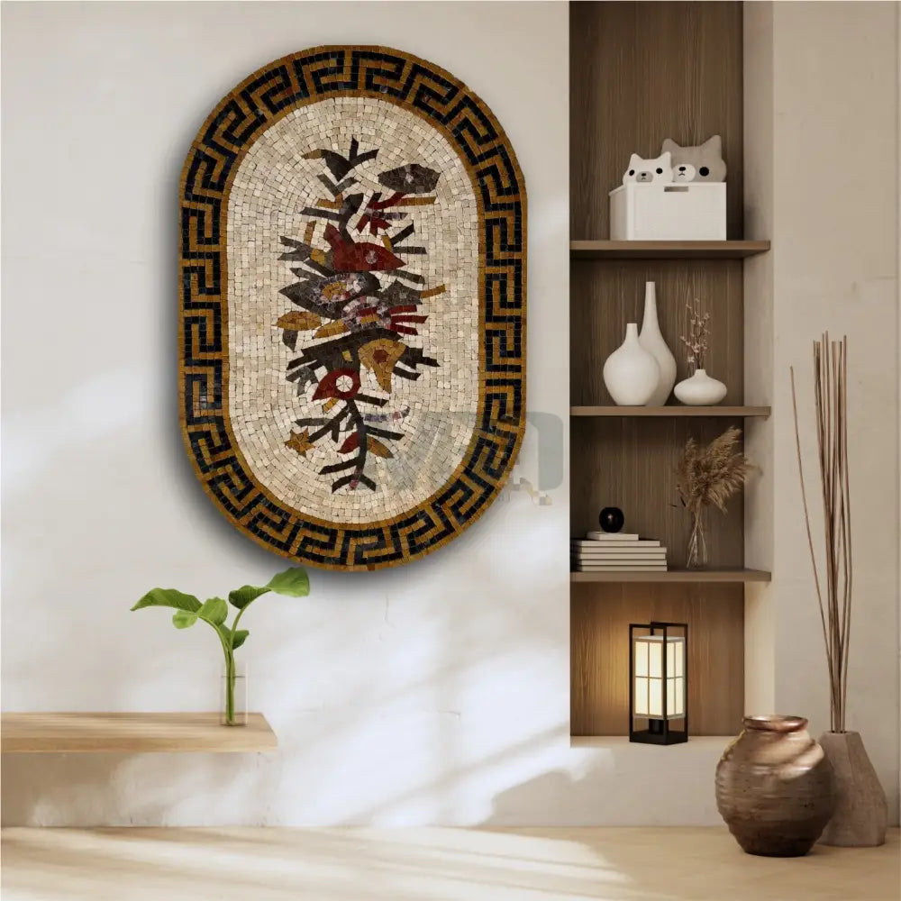 A floral patterned wall hanging artwork in a geometric frame, displayed on a wall above a bench with a cat statue, next to a shelf with books and a plant.